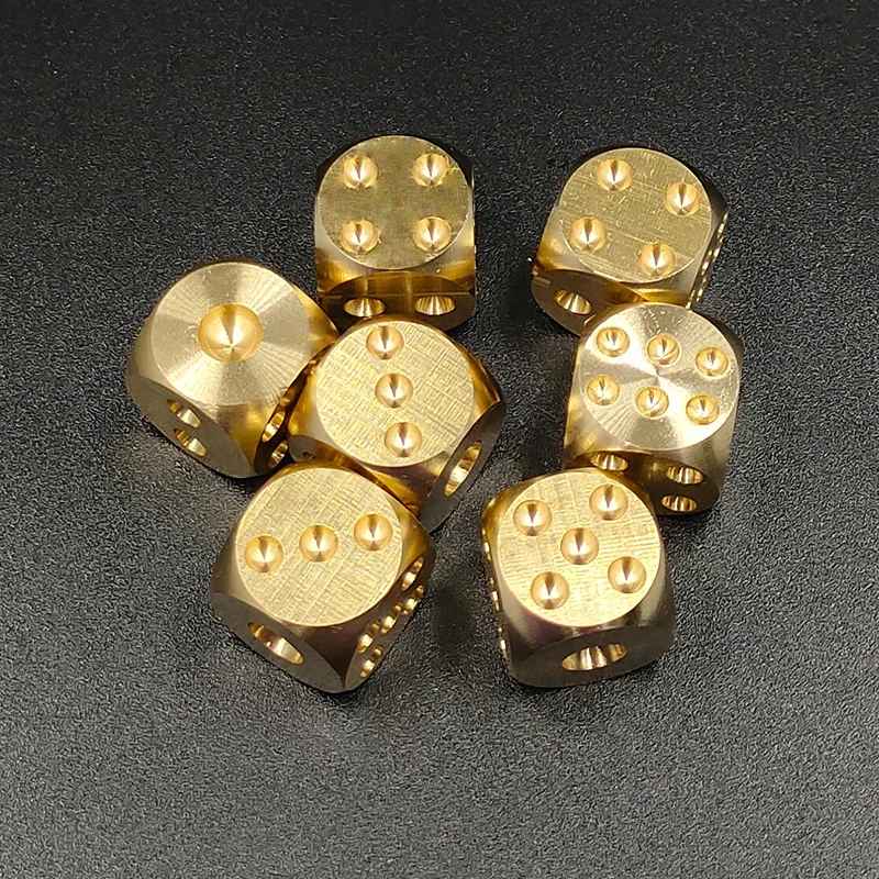 Solid brass dice pair for mahjong showing size and weight against hand