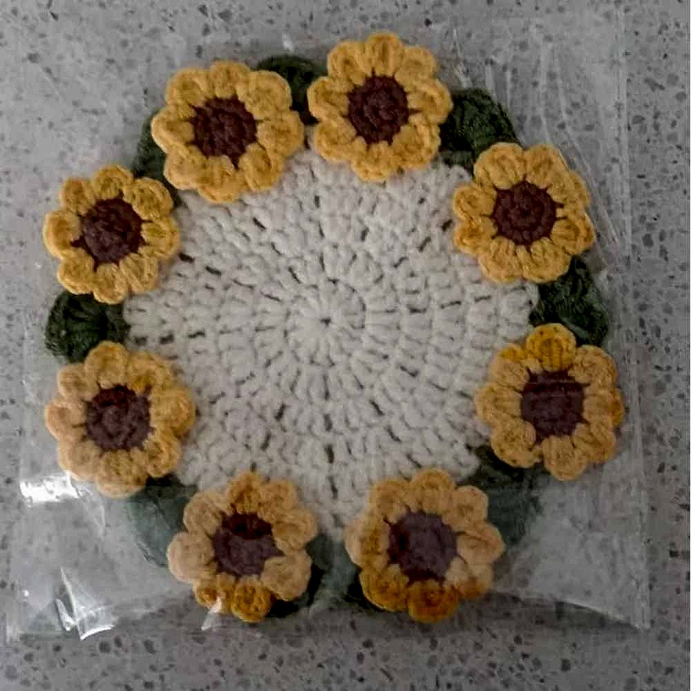 Handmade crochet sunflower coaster in yellow and brown tones, textured floral detail, shown flat on surface | BigMoetsy